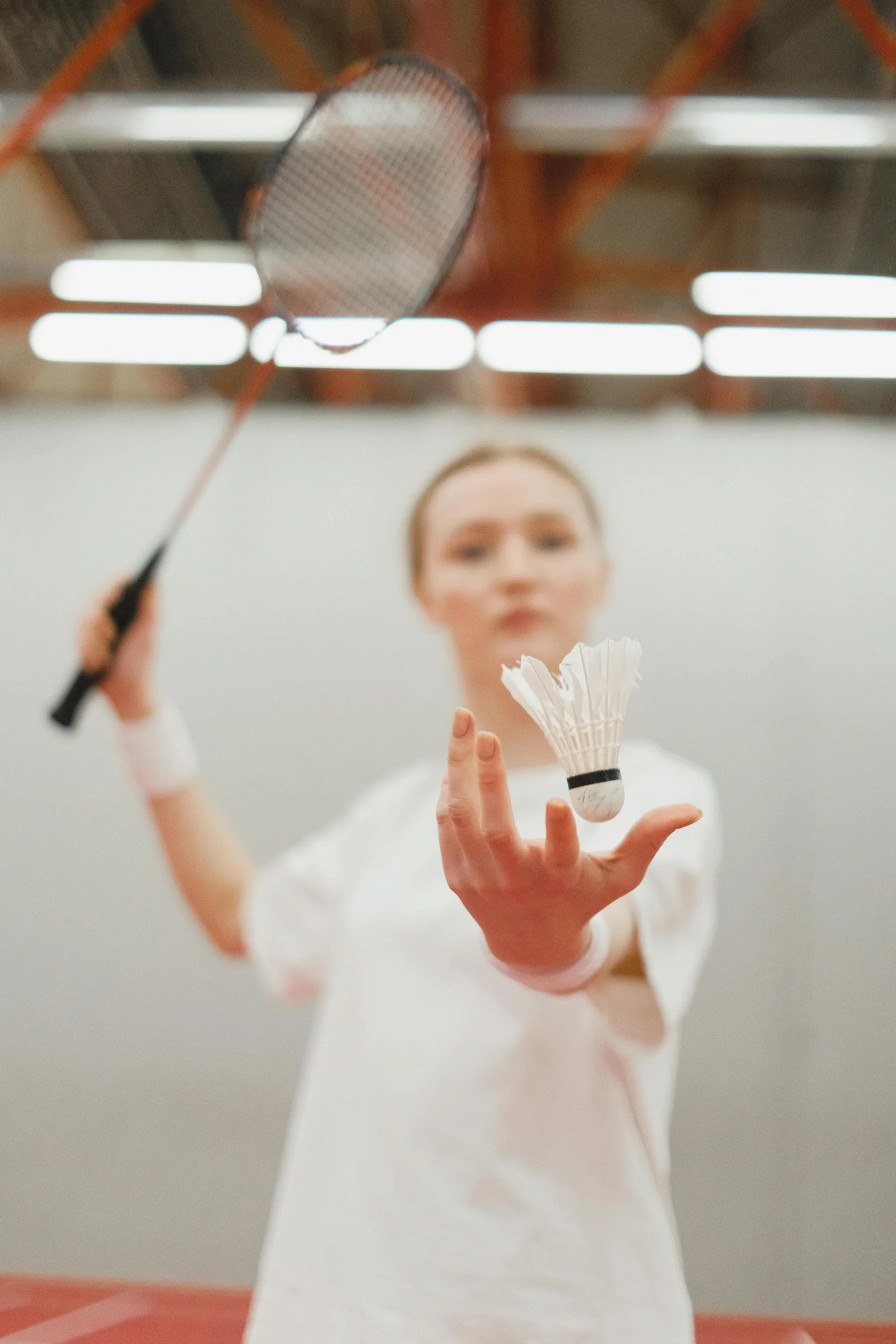 Badminton player serving with shuttlecock, analysing performance ceiling through stage data