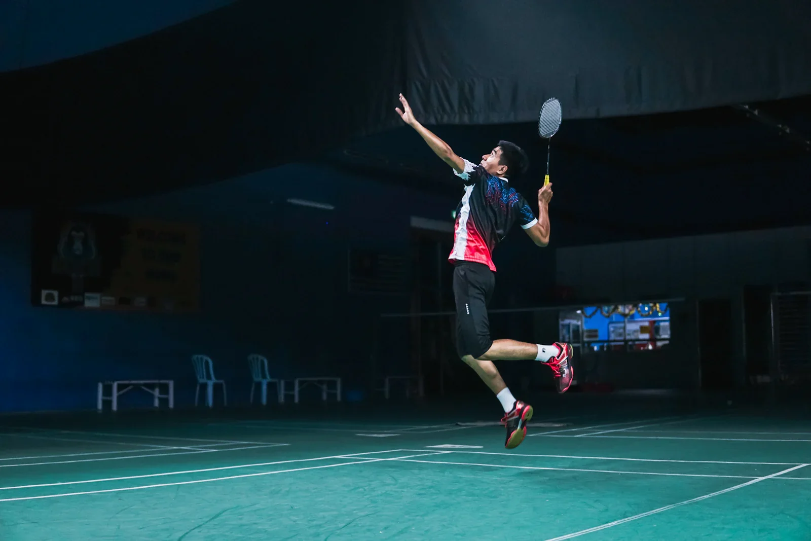 Professional badminton player executing a jump smash, representing elite player profile analysis