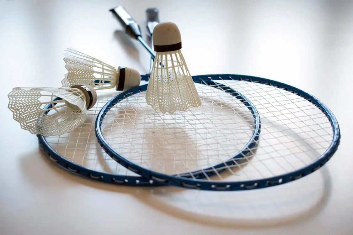 Two badminton rackets and shuttlecocks on white surface — periodization phases that define a peak performance season
